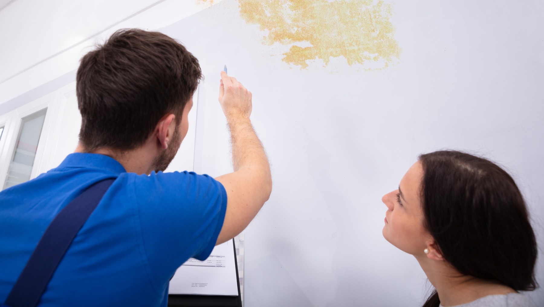 hombre-joven-examinando-humedad-en-pared